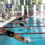 Foto von Schwimmern, die gerade einen Startsprung ins Schwimmbecken machen